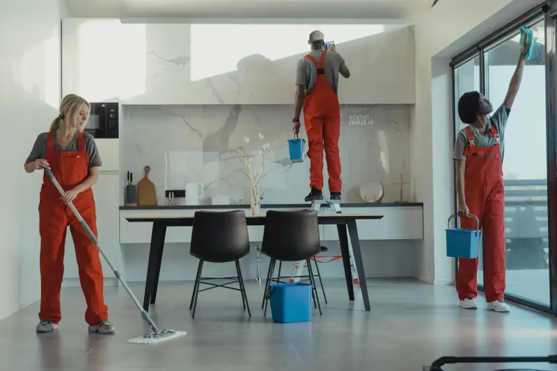 Team schoonmakers maakt een woonkeuken grondig schoon